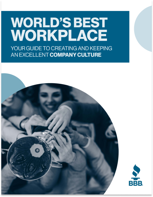 A trophy is held up in the air by multiple smiling people.